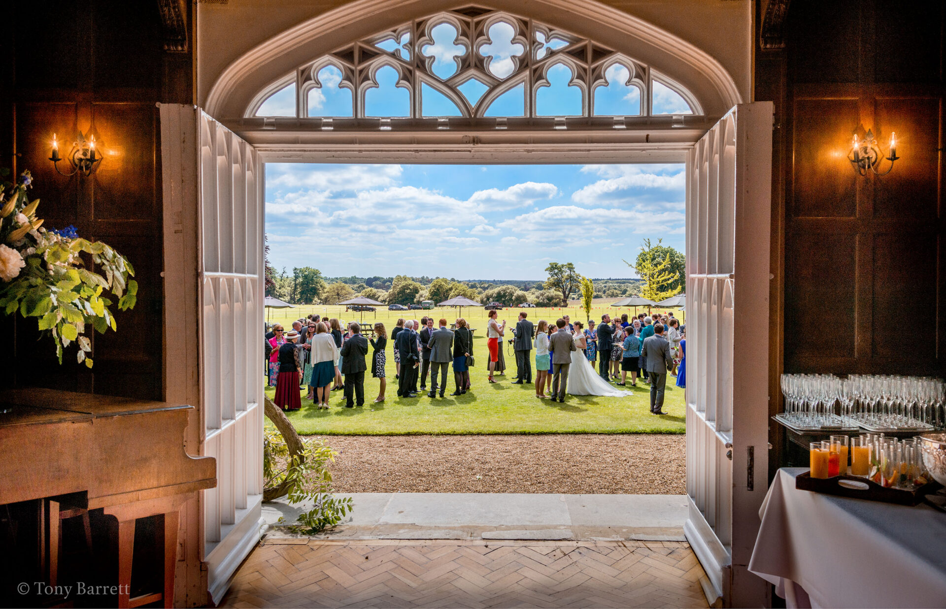A wedding celebration taking place in the Cumberland Lodge gardens