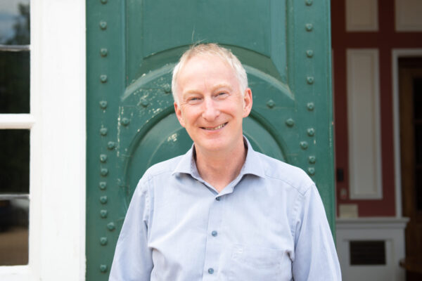 Chief Executive Dr Ed Newell standing in front of a green door