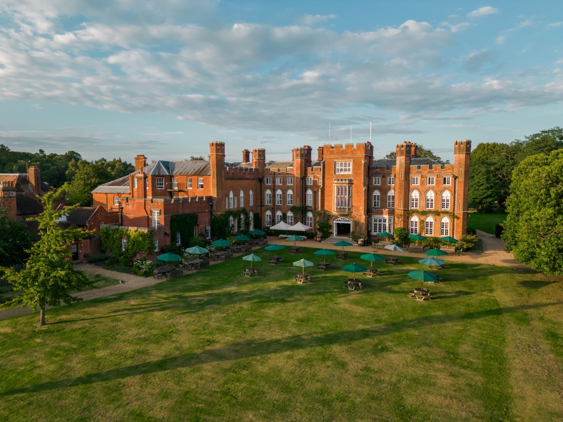 An aerial photo of the red brick Cumberland Lodge building and gardens