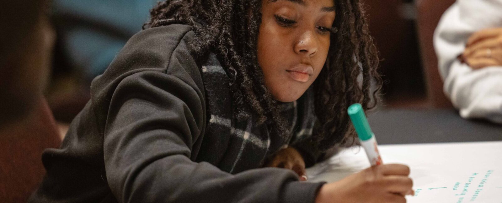 A workshop participant writing on a poster