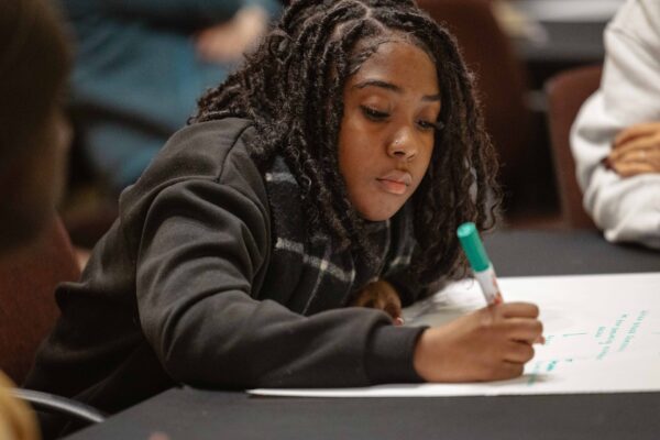 A workshop participant writing on a poster