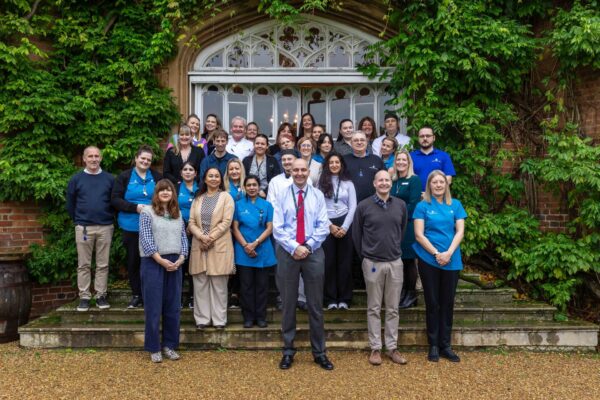 A group photo of Cumberland Lodge staff outside the Tapestry Hall doors